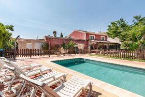 a swimming pool with lounge chairs and a house at Cortijo La Jimena in Benablón
