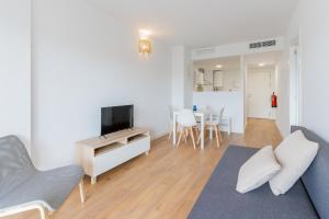 a living room with a couch and a tv at Canet Seaview Gem: Pool & Beach Proximity in Canet de Berenguer