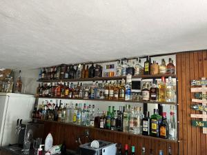 a shelf filled with lots of bottles of alcohol at The Byala Escape, Private Villa with Bar & Hot Tub in Byala