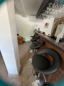 a bar with black stools in a room at The Byala Escape, Private Villa with Bar & Hot Tub in Byala