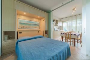 a bedroom with a blue bed and a dining room at Appartamenti Verde Blu in Capoliveri +120 photos