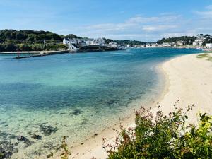 a beach with the ocean and houses in the background at Ti Marie Ly in Audierne