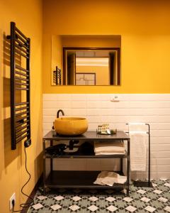 bagno con lavandino giallo e specchio di Foresteria del Teatro Donnafugata a Ragusa Altre 35 foto