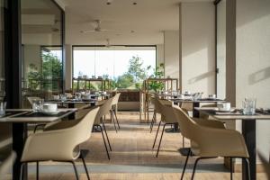 een restaurant met tafels en stoelen en een groot raam bij Residence Diana in Bibione