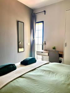 a bedroom with a bed and a desk and a window at Apartamento boutique luminoso a 5 min del metro in Bétera