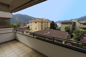 a balcony with a view of some buildings and mountains at Alle Vigne, 3 Stock by HolAp SA in Ascona