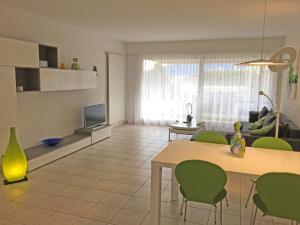 een woonkamer met een tafel en groene stoelen bij Alle Vigne, 3 Stock by HolAp SA in Ascona