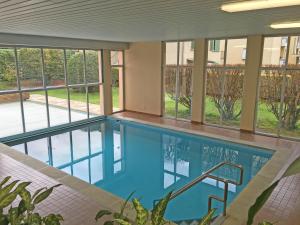 a swimming pool in a building with windows at Alle Vigne, 3 Stock by HolAp SA in Ascona