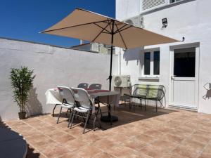 a patio with a table and chairs and an umbrella at Villa`s Safara in Safara