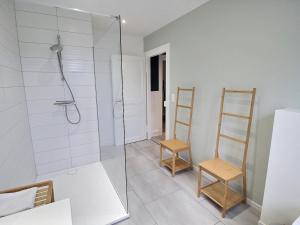 une salle de bain avec douche et deux chaises en bois dans l'établissement Appartement rénové à Colmar avec jardin et terrasse - FR-1-722-11, à Colmar 23 autres photos