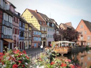 un bateau sur une rivière dans une ville avec des bâtiments dans l'établissement Appartement rénové à Colmar avec jardin et terrasse - FR-1-722-11, à Colmar