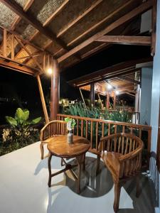 a patio with two chairs and a table at Golden Beach Hotel Lombok in Pulau Gilipoh