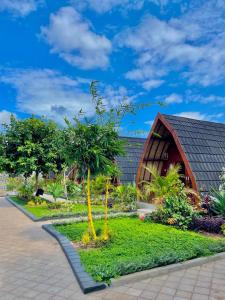 a house with a garden in front of it at Golden Beach Hotel Lombok in Pulau Gilipoh