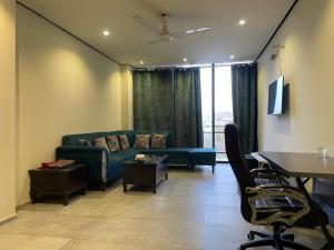 a living room with a blue couch and a table at Sunrise Villa in Islamabad +6 photos