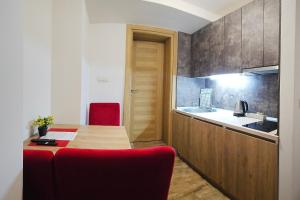 a kitchen with a wooden table and a red chair at Villa Montemaris Budva in Budva