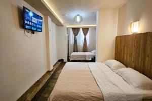 a hotel room with two beds and a flat screen tv at Villa Montemaris Budva in Budva