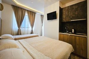 a hotel room with two beds and a television at Villa Montemaris Budva in Budva