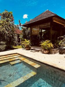 a swimming pool in front of a house at Beautiful 3br bohemian villa in Sanur