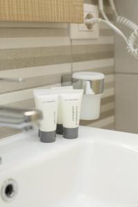 zwei Tassen auf einer Theke neben einem Waschbecken in der Unterkunft Rio Boutique Hotel Vlore in Vlorë + 123 Fotos