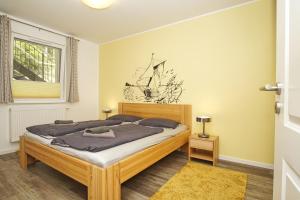 una camera da letto con un letto in una stanza con una finestra di Residenz Waldidyll FeWo Kleiner Stubber - ruhige Lage, mit Sauna- und Schwimmbadnutzung im AHOI Sellin a Ostseebad Sellin Altre 32 foto