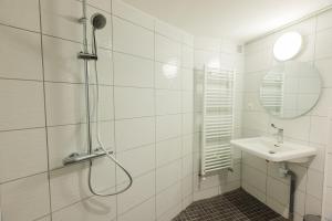 a white bathroom with a shower and a sink at Maison Yasmyn in Villeurbanne