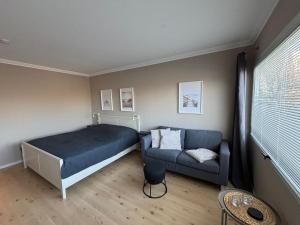 a bedroom with a bed and a couch at Seeblick in Fehmarn