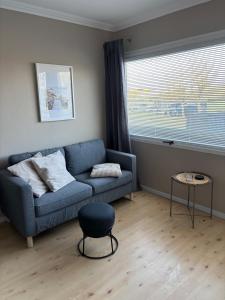 a living room with a blue couch and a window at Seeblick in Fehmarn +2 photos