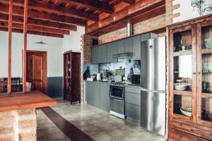 a kitchen with a stainless steel refrigerator and a table at Nemeskerék Vendégház in Nemesnép