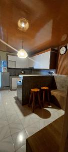 a kitchen with a counter and two stools in it at Kubumade in Sanur
