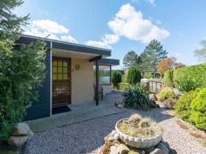a small house with a door in a garden at Holiday Home Sint Maartenszee near Beach in Sint Maartensvlotbrug +18 photos