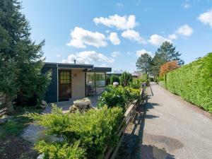 a small house with a garden and a walkway at Holiday Home Sint Maartenszee near Beach in Sint Maartensvlotbrug