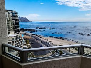 ストランドにあるPENTHOUSE Luxury Apartment Amazing Sea Views CAPE TOWNの海とビーチの景色を望むバルコニー