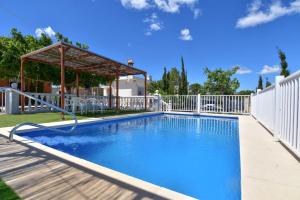 a swimming pool in a yard with a white fence at Exclusive Villa in Catadau: Pool & Private Gardens in Catadau