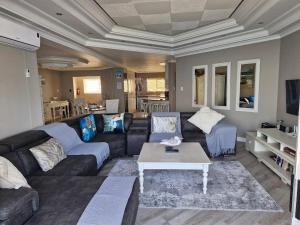 ストランドにあるPENTHOUSE Luxury Apartment Amazing Sea Views CAPE TOWNのソファとコーヒーテーブルのあるリビングルーム