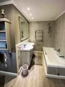 ストランドにあるPENTHOUSE Luxury Apartment Amazing Sea Views CAPE TOWNの浴槽と洗面台とバスタブを備えたバスルーム