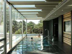 a pool in a house with a child in it at Hostal Empúries in L'Escala