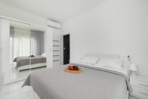 a bedroom with a bed with a bowl of fruit on it at Paraiso Nadmorskie Apartamenty z Basenem i Parkingiem by Noclegi Renters in Łukęcin