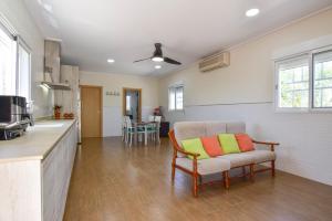 a living room with a chair and a kitchen at Exclusive Villa in Catadau: Pool & Private Gardens in Catadau
