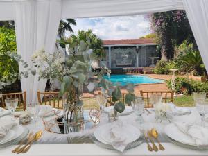 a white table with plates and flowers on it at Sun and Stars in Benoni