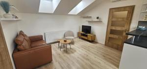 a living room with a couch and a table and a television at Apartmán Tereza in Kutná Hora