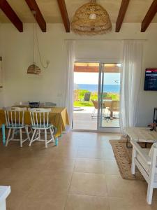a dining room with a table and a view of the ocean at Villa Calma in Cala'n Bosch