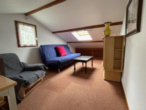 ein Wohnzimmer mit einem blauen Sofa und einem Sessel in der Unterkunft Maison T2 indépendante avec terrasse et parking in Buxerolles