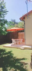ein Tisch und Stühle unter einem Sonnenschirm auf einer Terrasse in der Unterkunft Maison T2 indépendante avec terrasse et parking in Buxerolles