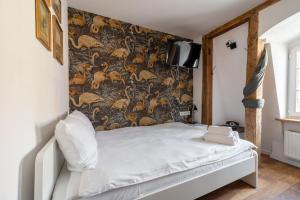 a bedroom with a bed and a wall with a wallpaper at RentPlanet - Studio Rynek Ratusz in Wrocław