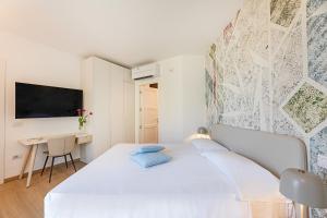 a white bedroom with a bed and a desk at Hotel Baia Imperiale in Campo nell'Elba +37 photos