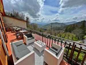 a balcony with chairs and tables and a view of mountains at Casa Bicocchi in Lanciole