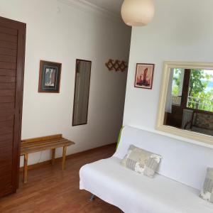 a living room with a white couch and a window at Günebakan Taliani Otel in Ayvalık