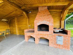 a brick fireplace in a patio with a wooden ceiling at Cabana Twins A-Frame 1 in Sibiu
