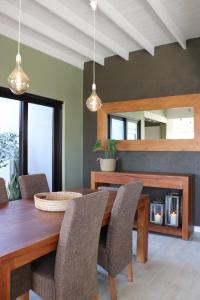 a dining room with a wooden table and chairs at Salty Villa in Swakopmund