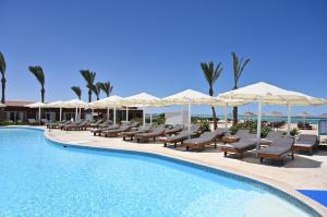 a pool with chairs and umbrellas at a resort at Riviera Aqua Park Resort in Hurghada